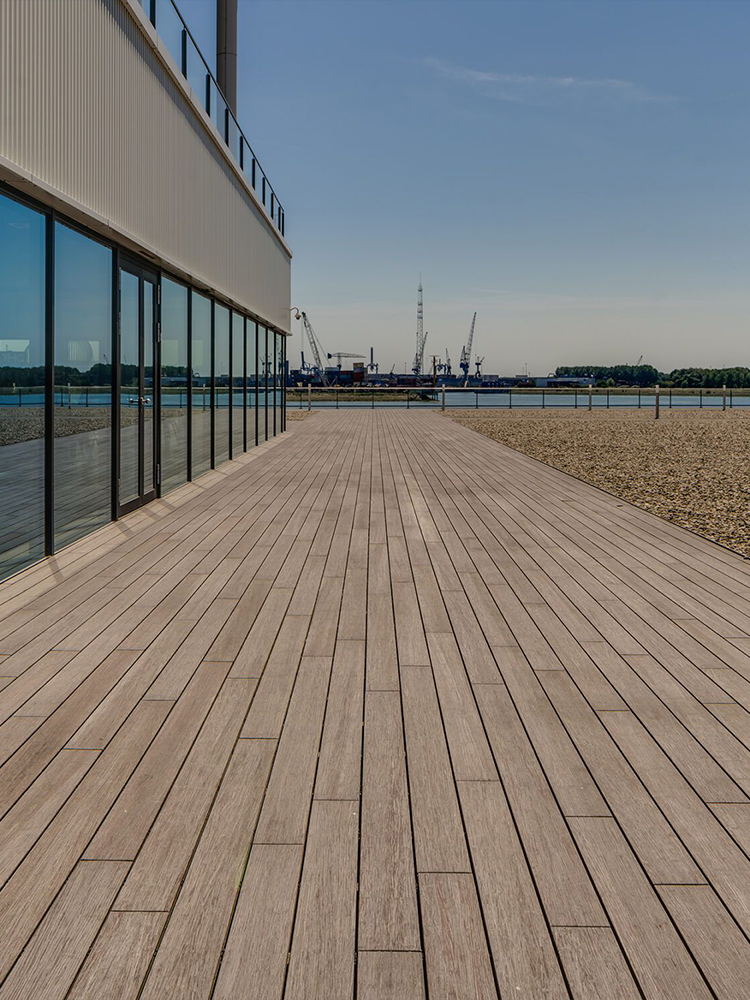 Three construction workers applying bright light blue waterproof coating on outdoor balcony